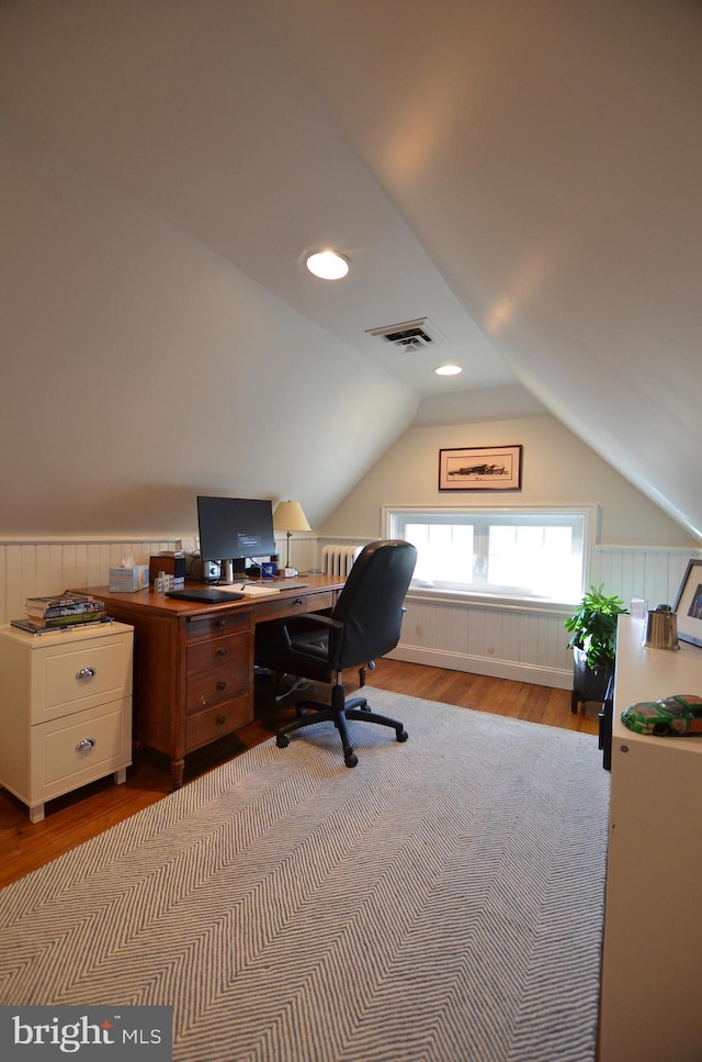 home office with wood-type flooring and vaulted ceiling