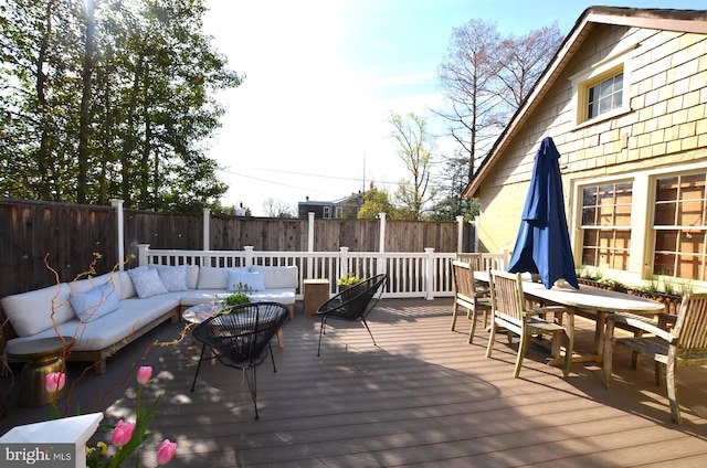 wooden terrace with an outdoor living space