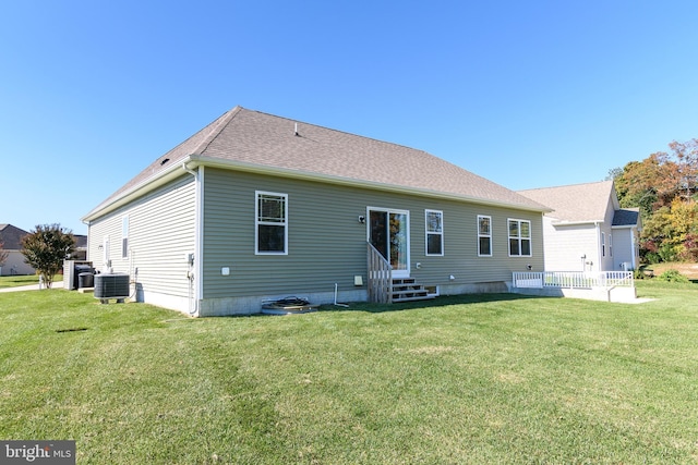 back of property with a lawn and central AC