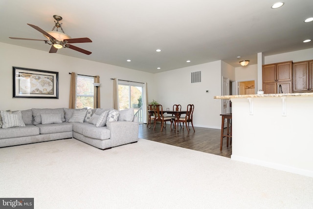 living room featuring ceiling fan and dark hardwood / wood-style floors