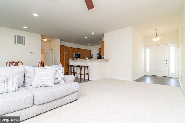 living room featuring ceiling fan and dark wood-type flooring