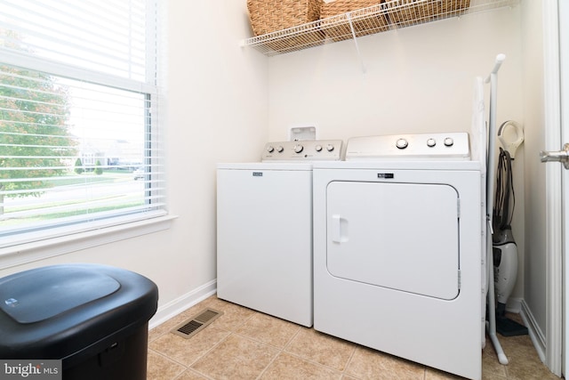 clothes washing area featuring independent washer and dryer and light tile patterned floors