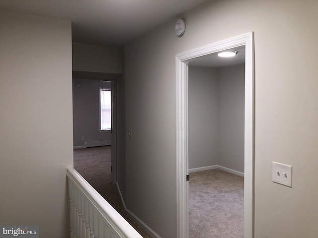 hallway featuring carpet, baseboards, and baseboard heating