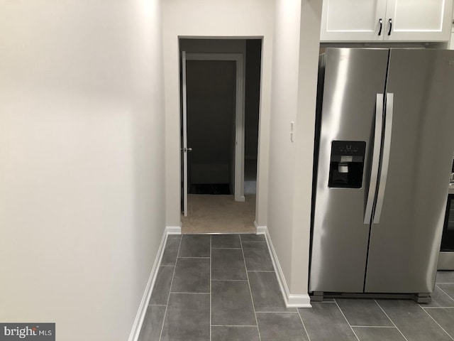 hallway with dark tile patterned flooring