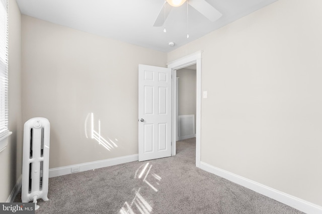 carpeted spare room featuring ceiling fan