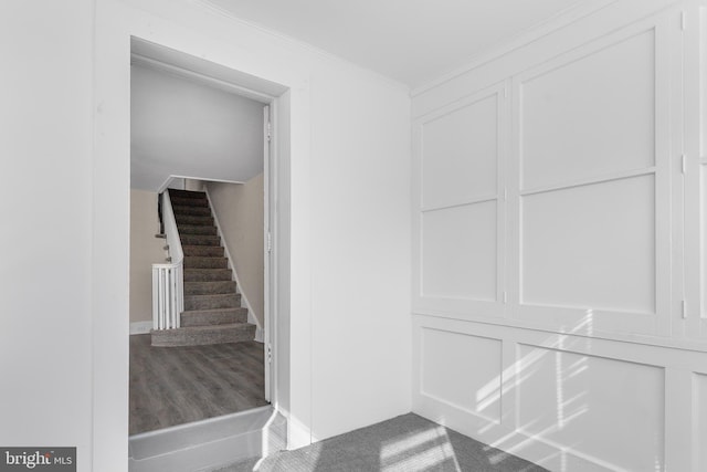 stairs featuring crown molding and wood-type flooring