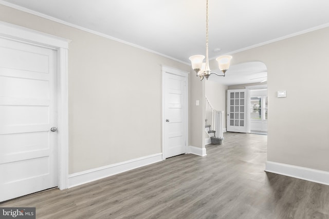 unfurnished dining area with ornamental molding, hardwood / wood-style flooring, and a notable chandelier