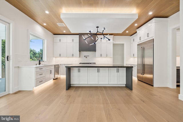 kitchen with white cabinetry, appliances with stainless steel finishes, sink, and a kitchen island