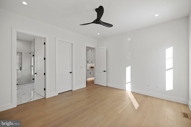 unfurnished bedroom featuring connected bathroom, light wood-type flooring, and ceiling fan