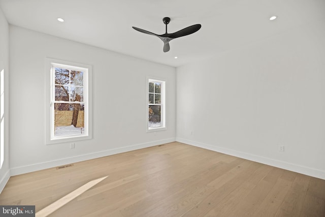 empty room with ceiling fan, a healthy amount of sunlight, and light hardwood / wood-style floors