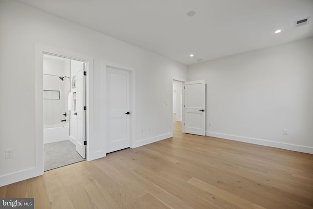 unfurnished bedroom with connected bathroom and light hardwood / wood-style floors