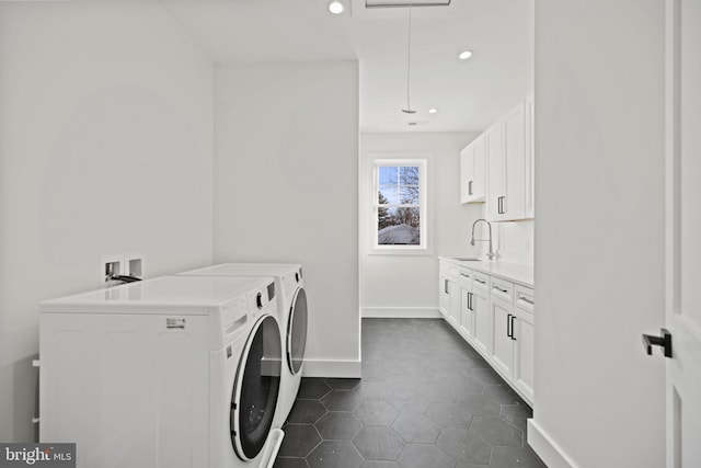 washroom with cabinets, sink, washer and dryer, and dark tile patterned floors