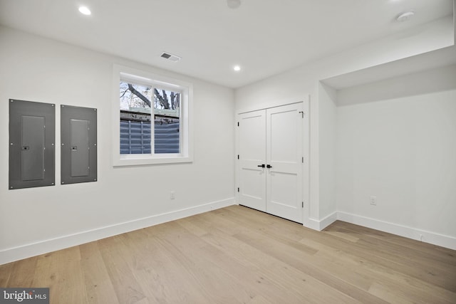 unfurnished bedroom with electric panel and light wood-type flooring