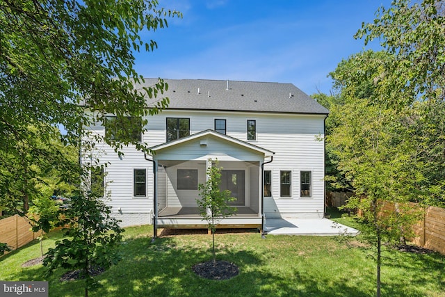 back of house with a patio area and a lawn