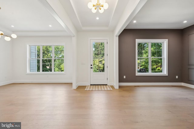 foyer with an inviting chandelier, light hardwood / wood-style flooring, and plenty of natural light