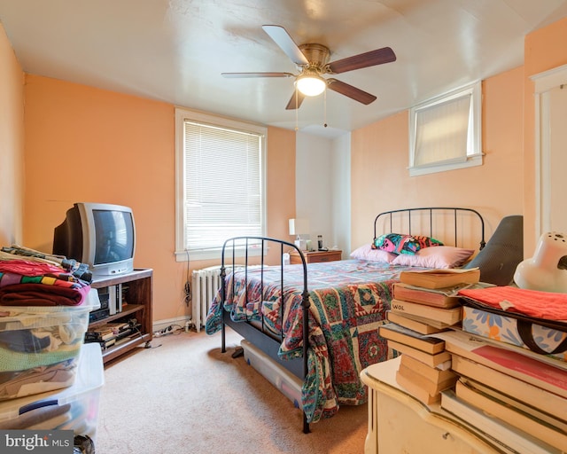 carpeted bedroom with radiator and ceiling fan