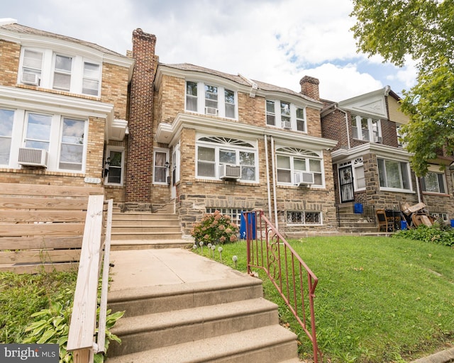 townhome / multi-family property with cooling unit and a front lawn