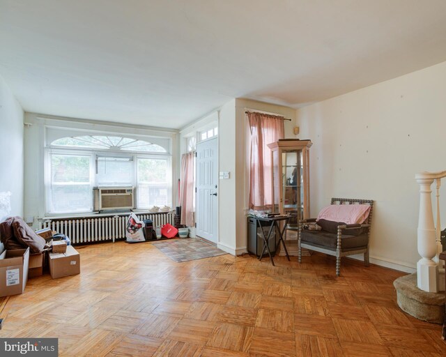 living area with radiator heating unit, parquet flooring, and cooling unit