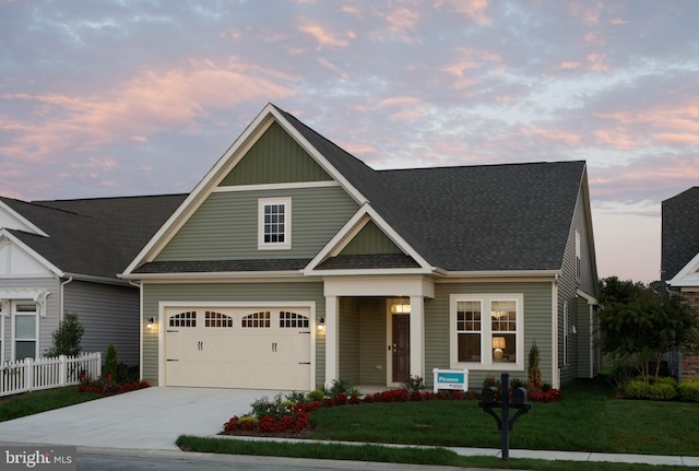 craftsman inspired home featuring a garage and a yard