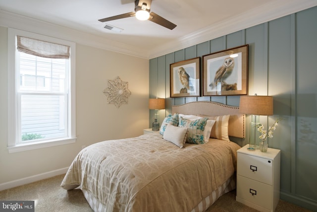 carpeted bedroom featuring crown molding and ceiling fan