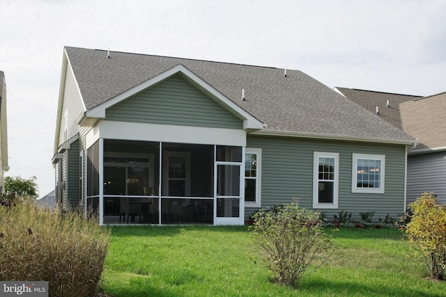 rear view of property featuring a sunroom and a yard