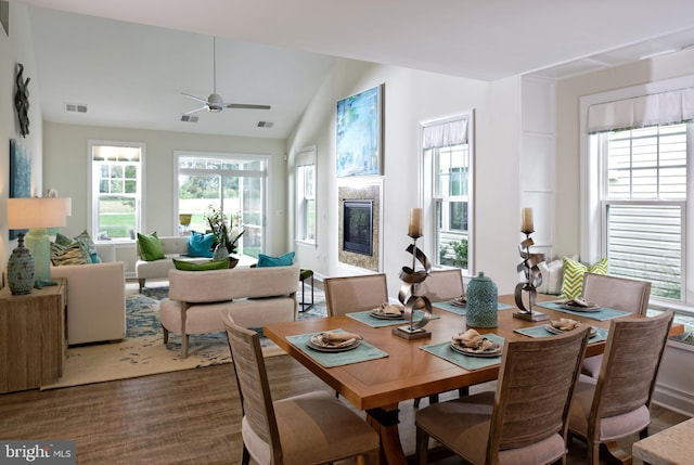 dining area with ceiling fan, wood-type flooring, and lofted ceiling