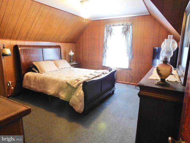 carpeted bedroom with vaulted ceiling and wood walls