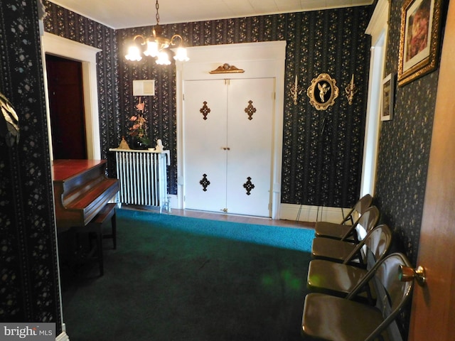 sitting room with carpet flooring, radiator heating unit, and a notable chandelier