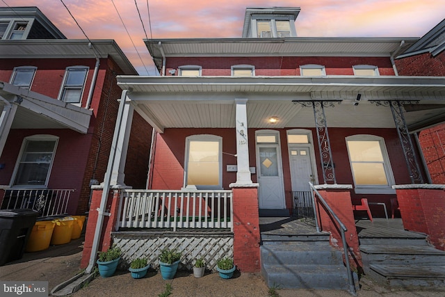 townhome / multi-family property featuring a porch