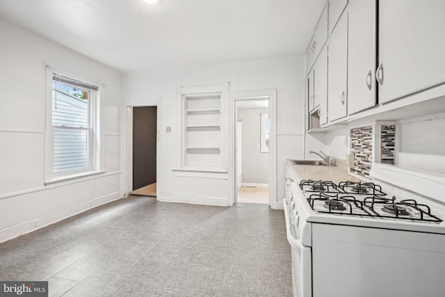 kitchen with white cabinetry, sink, and white gas stove