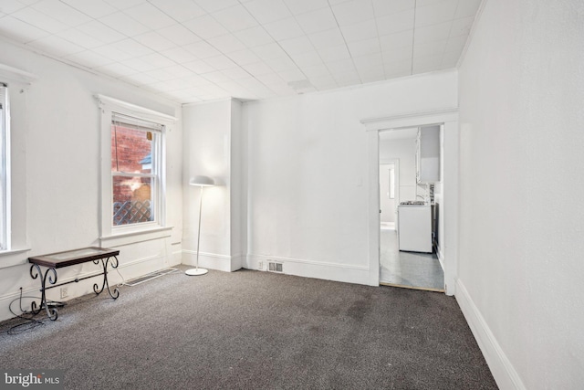 carpeted spare room featuring washer / clothes dryer and crown molding