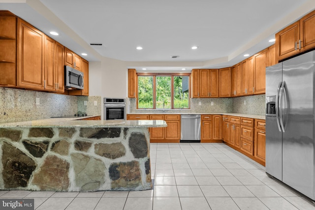 kitchen featuring stainless steel appliances, backsplash, kitchen peninsula, and light tile patterned floors