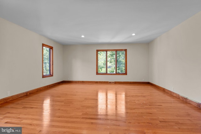 spare room with a healthy amount of sunlight and light hardwood / wood-style flooring