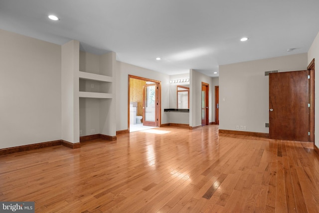 unfurnished living room featuring light hardwood / wood-style flooring and built in features