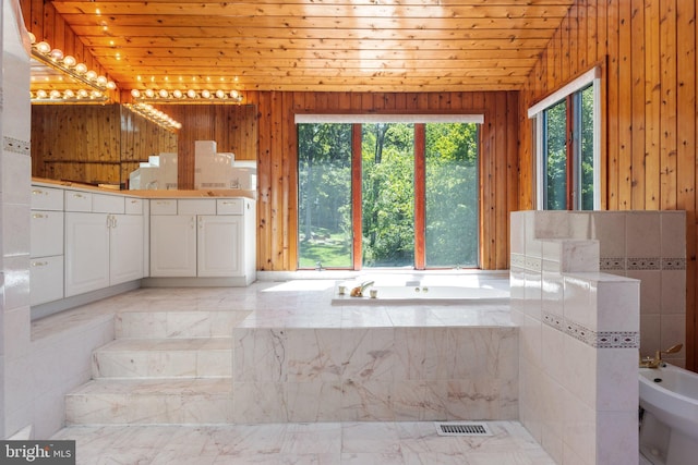 bathroom featuring a bidet, wood ceiling, and a healthy amount of sunlight