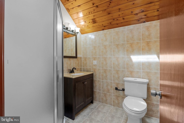 bathroom featuring vanity, toilet, wooden ceiling, tile walls, and tile patterned flooring