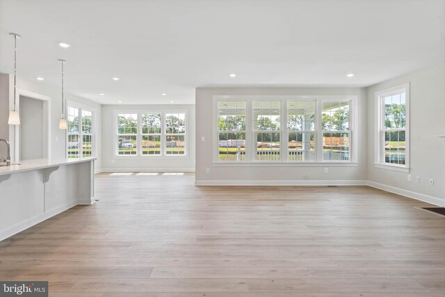 home office featuring a notable chandelier, wood-type flooring, and a wealth of natural light