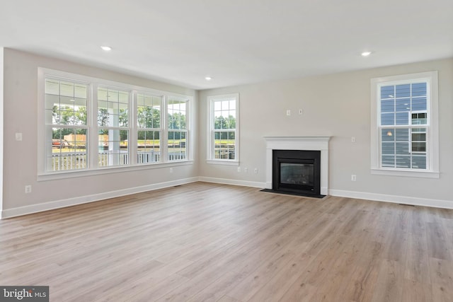 unfurnished living room with light hardwood / wood-style flooring and plenty of natural light