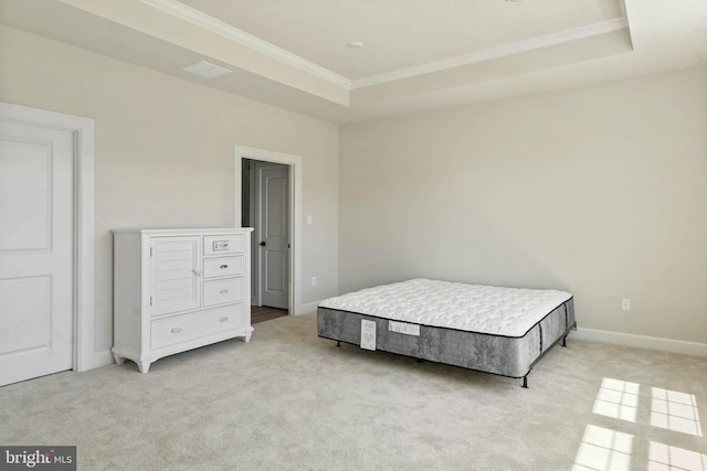 carpeted bedroom with ornamental molding and a tray ceiling