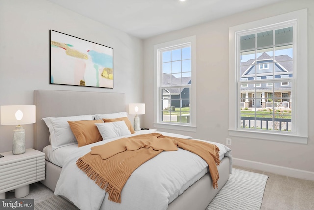 carpeted bedroom featuring multiple windows