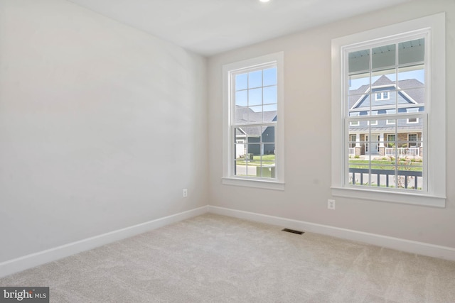 carpeted spare room featuring a wealth of natural light