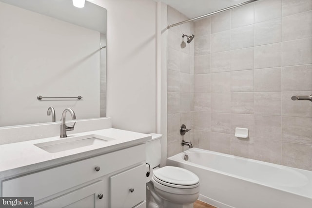 full bathroom with tiled shower / bath, vanity, and toilet