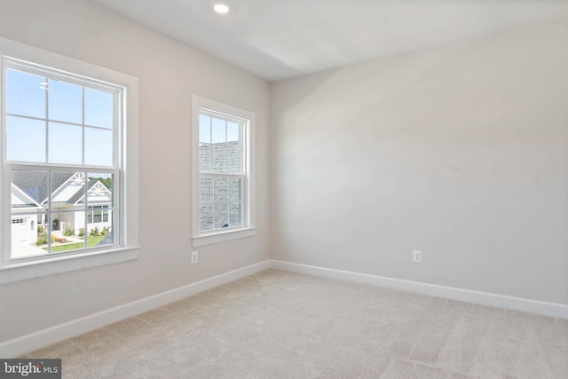 unfurnished room featuring light carpet