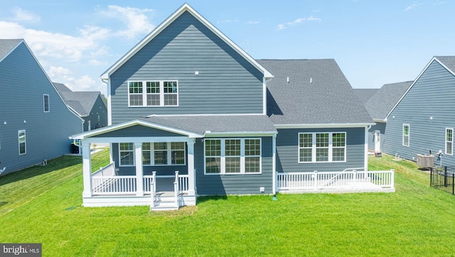 rear view of property with central AC unit, a yard, and covered porch