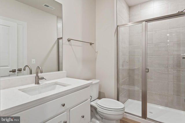 bathroom featuring walk in shower, vanity, and toilet