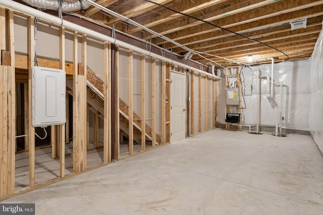 basement featuring water heater and electric panel