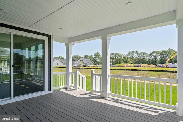 wooden terrace with a lawn