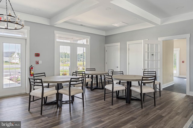 dining space with dark wood-type flooring, beamed ceiling, a wealth of natural light, and an inviting chandelier