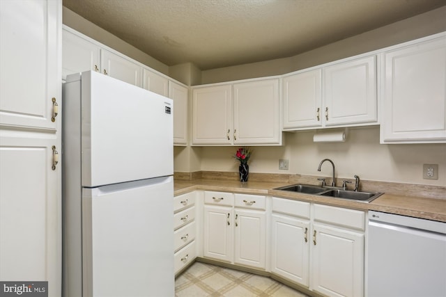 kitchen with white cabinetry, white appliances, and sink