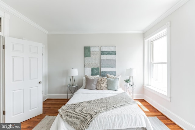 bedroom with hardwood / wood-style floors and ornamental molding